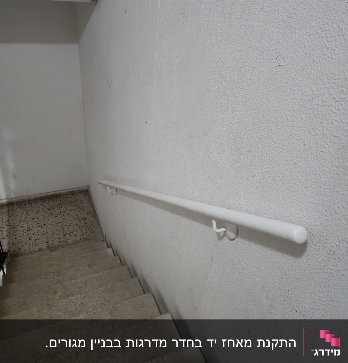 מעקה לבן מותקן על קיר מדרגות